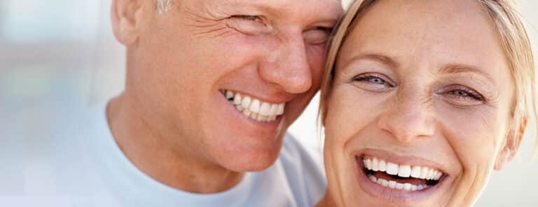 photo of couple with beautiful full dental arch implants