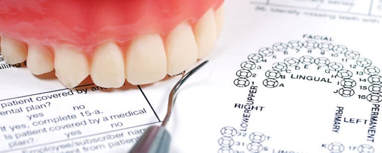 Dentures on top of dental exam documents