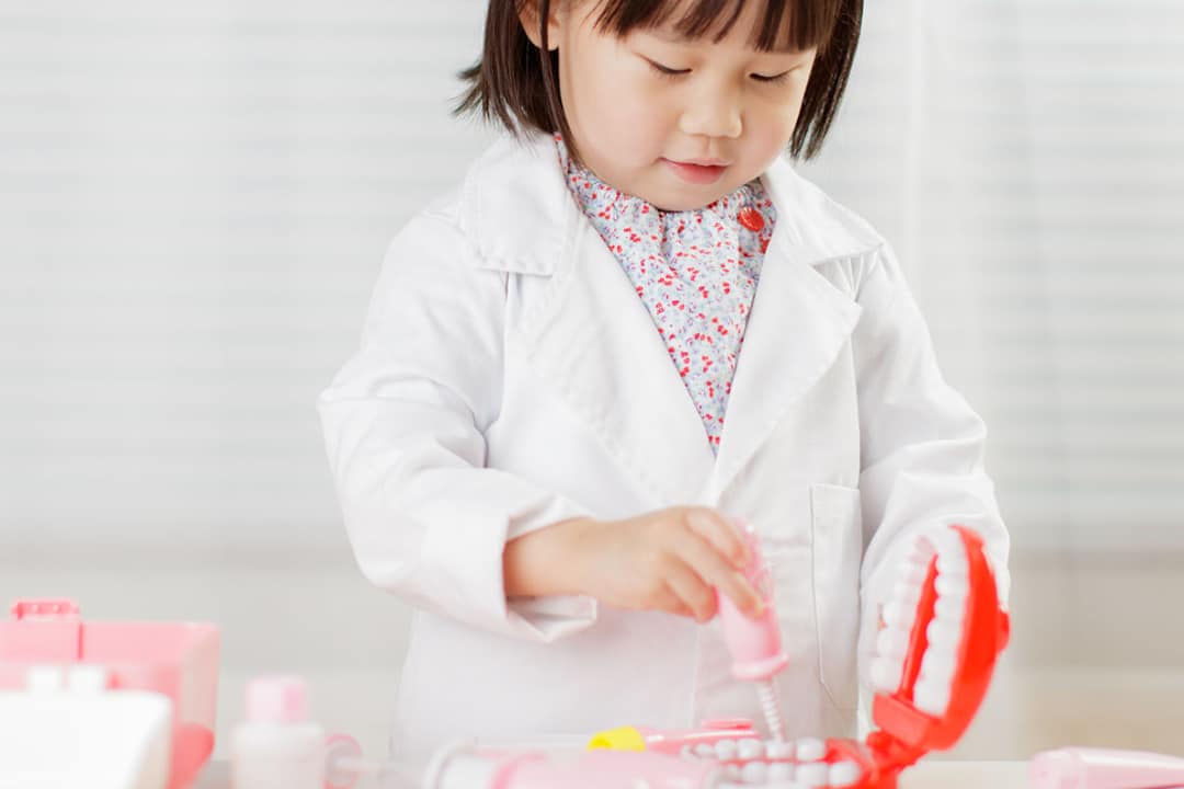 Child practicing Preventative Dentistry with toy dentures