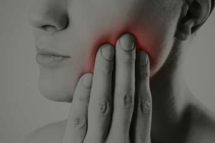 Person with oral pain holding cheek